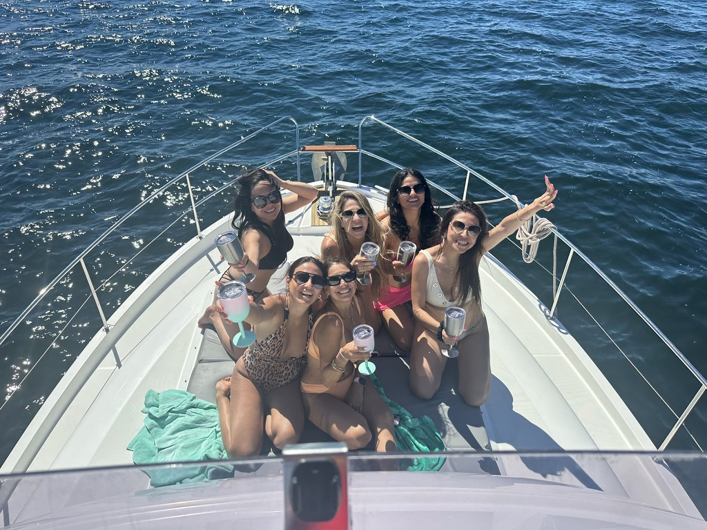 Guests toasting on the bow of the charter yacht on a sunny day